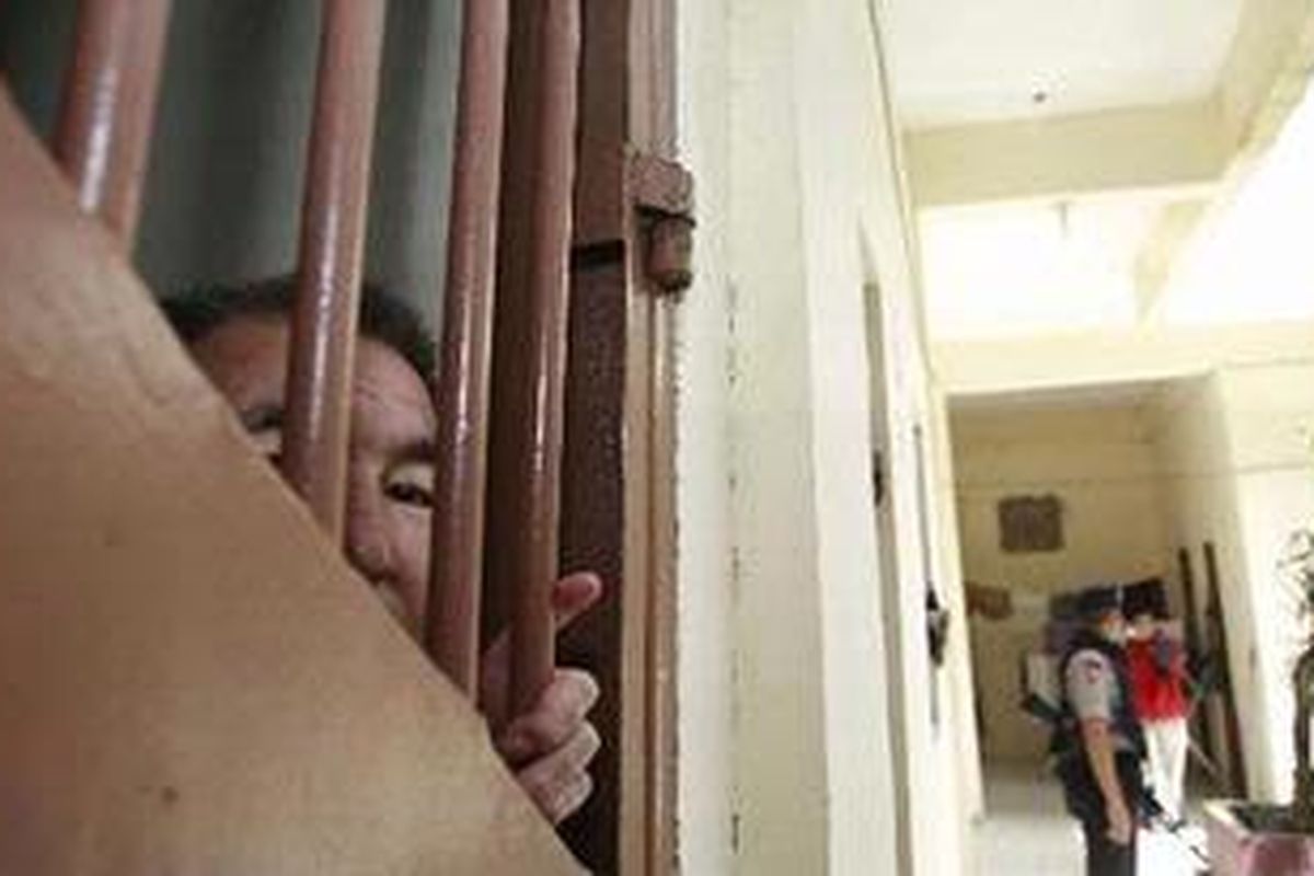 Ali (52), seorang imigran asal Afghanistan mengintip dari balik kamar tahanan di Rumah Detensi Imigrasi Pekanbaru, Minggu (5/12/2010). Sebanyak 29 imigran Afghanistan berhasil kabur dengan membuat sebuah terowongan yang menembus hingga ke bagian luar Rudenim tersebut pada Sabtu (4/12/2010) malam.