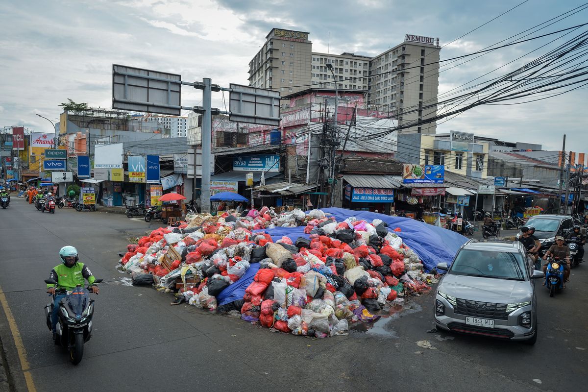 Kendaraan melintas di dekat tumpukan sampah di Ciputat, Kota Tangerang Selatan, Banten, Jumat (26/12/2025). Menindaklanjuti perintah Presiden Prabowo Subianto, Menteri LH Hanif Faisol Nurofiq minta pemerintah daerah kosisten mengelola limbahnya. 