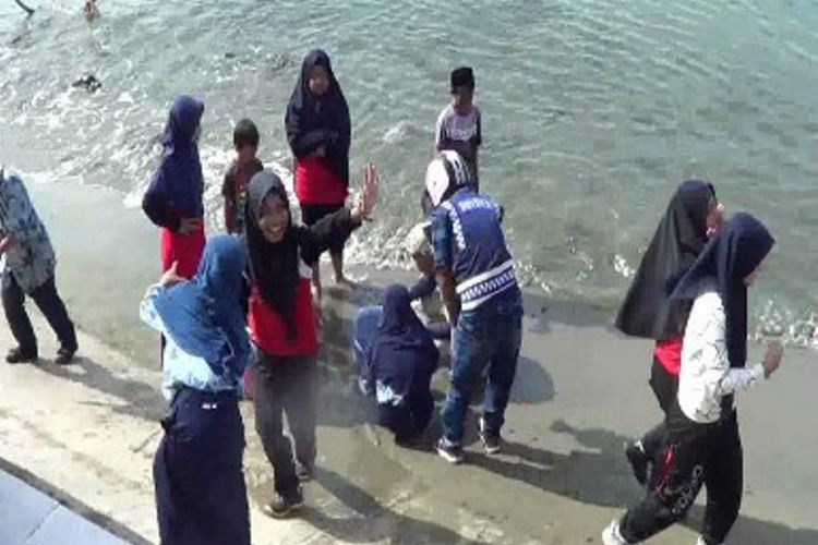 Warga mengambil air tawar yang menyembur di pantai Polewali Mandar.