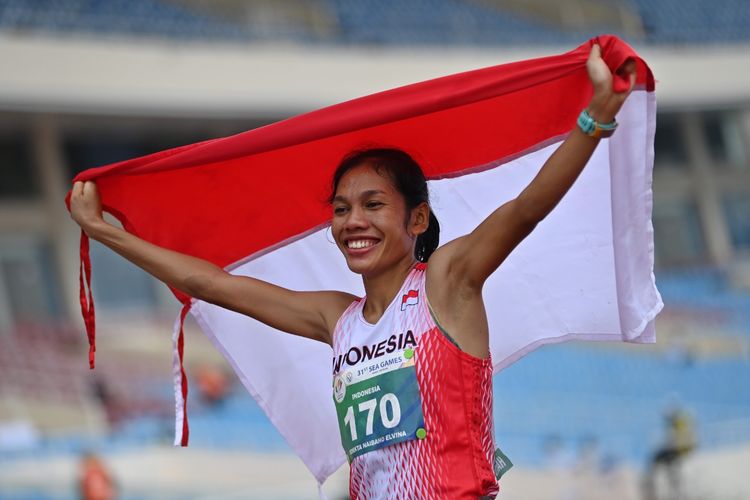 Pelari Indonesia Odekta Elvina Naibaho membentangkan bendera Merah Putih usai memenangi nomor lari maraton putri SEA Games Vietnam 2021 di Stadion Nasional My Dinh, Hanoi, Vietnam, Kamis (19/5/2022). Odekta berhasil merebut medali emas setelah menempuh jarak sejauh 42 kilometer dan finis pertama dengan catatan waktu 2 jam 55 menit 27 detik.