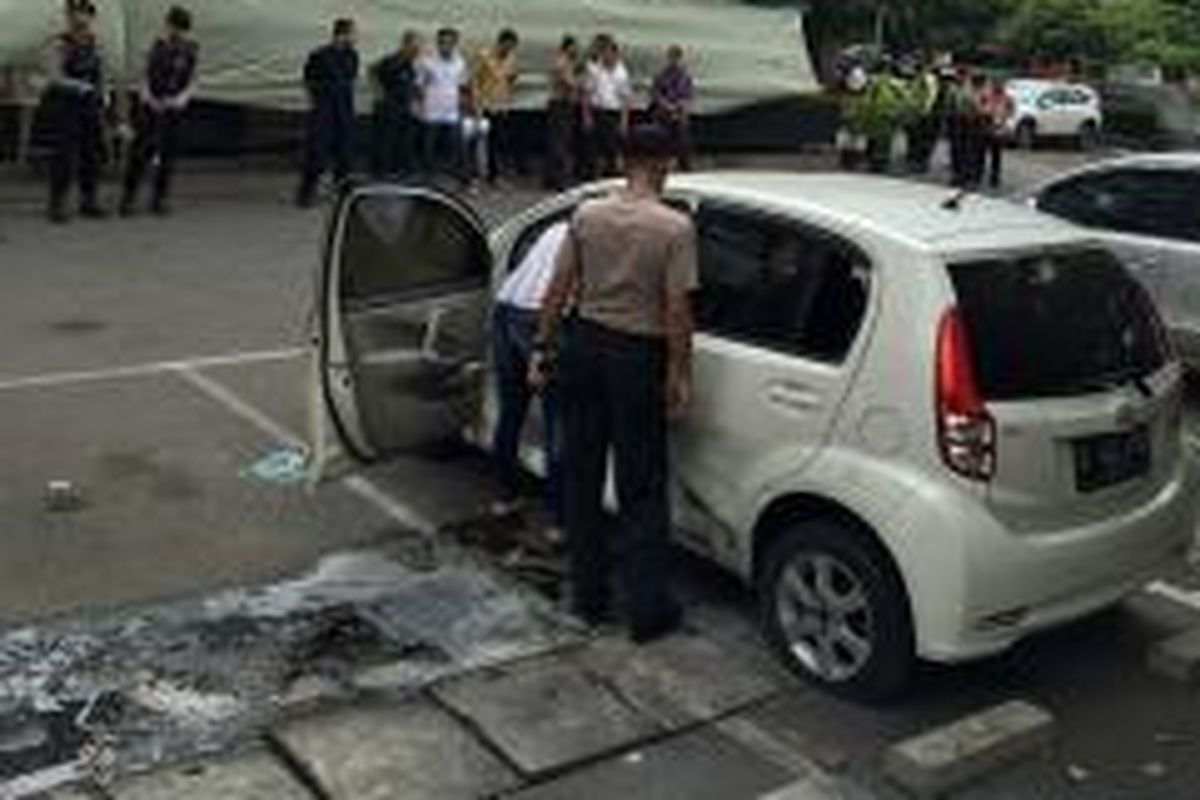 Mobil Daihatsu Sirion saat hendak akan dievakuasi dari halaman Starbucks Sarinah pada Jumat (15/2/2016). Mobil putih ini menjadi tempat para teroris berlindung saat baku tembak di halaman Starbuck Sarinah pada Kamis kemarin.