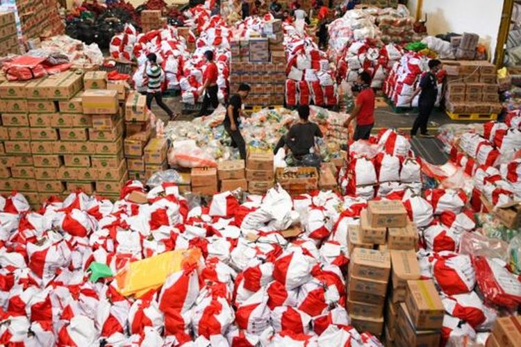 Pekerja mengemas paket bantuan sosial (bansos) di Gudang Food Station Cipinang, Jakarta, Rabu (22/04). 