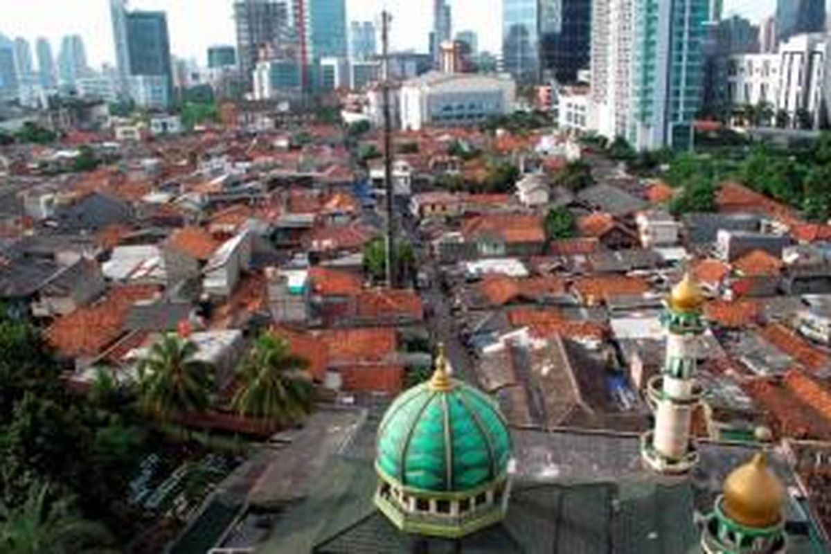 Permukiman padat penduduk yang dikelilingi gedung bertingkat di Kuningan, Jakarta Selatan, Minggu (12/5/2013).