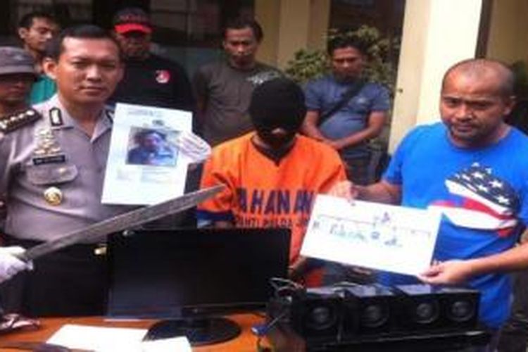 Polisi menunjukkan foto Joko semasa hidup dan seorang tersangka berikut sejumlah barang di Mapolda Jatim (17/3/2015). 
