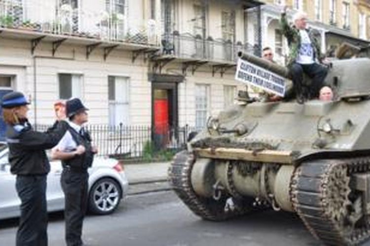 Para pedagang di kota Bristol mengendarai tank Sherman buatan masa Perang Dunia II berkeliling kota sebagai bentuk protes atas rencana pemerintah melakukan pembatasan parkir. Aksi mengendarai tank ini mendapat banyak perhatian, termasuk dari dua polisi wanita ini.