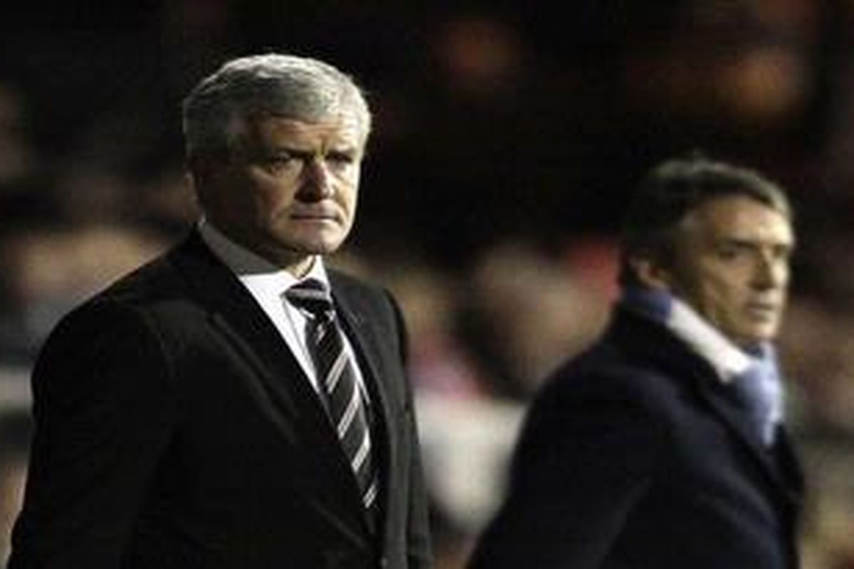 Pelatih Fulham Mark Hughes (kiri) menyaksikan timnya melawan Manchester City, Minggu (21/11/2010).