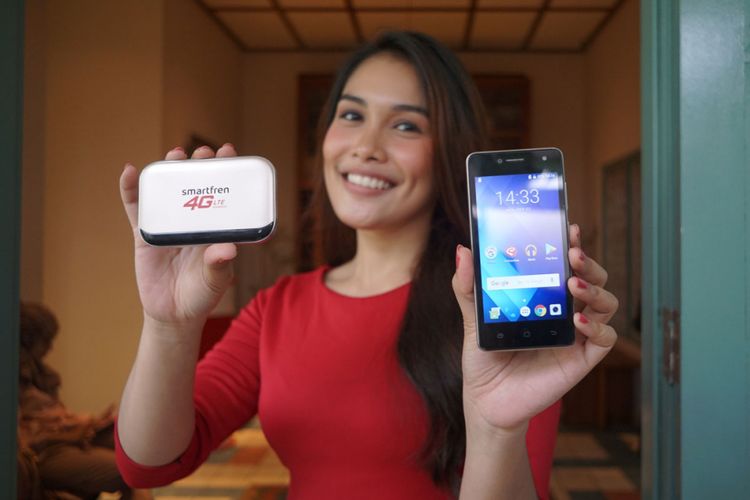 Model sedang memamerkan modem MiFi M5 dan smartphone Andromax A2                               