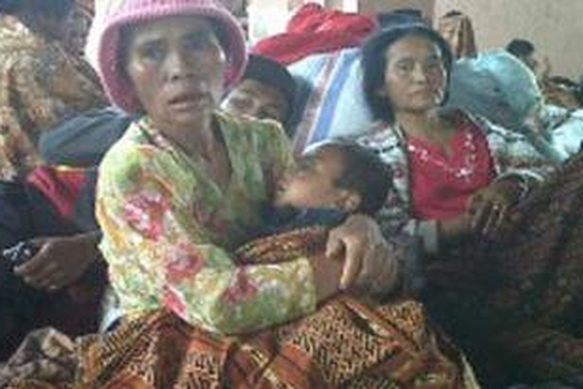 Ukur Milala (58), salah seorang pengungsi Sinabung menggendong cucunya, Asmi Milala (4) di posko pengungsian Sempa Kata, Senin (30/8/2010) siang.