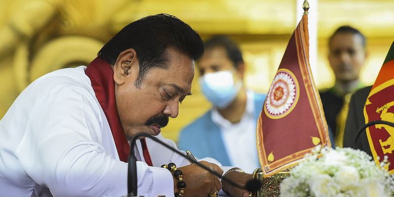 Perdana Menteri Sri Lanka Mahinda Rajapaksa saat menandatangani dokumen dalam upacara penyumpahan di kuil sakral Budha Kelaniya Raja Maha, luar ibu kota Colombo, 9 Agustus 2020. PM Sri Lanka mundur pada Senin (9/5/2022) buntut dari krisis ekonomi parah dan demo besar yang melanda negara.