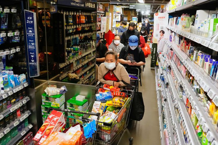 Orang-orang yang memakai masker mengantre untuk membayar karena penduduk khawatir tentang kekurangan makanan segar di pasar di Hong Kong Senin, 28 Februari 2022. 