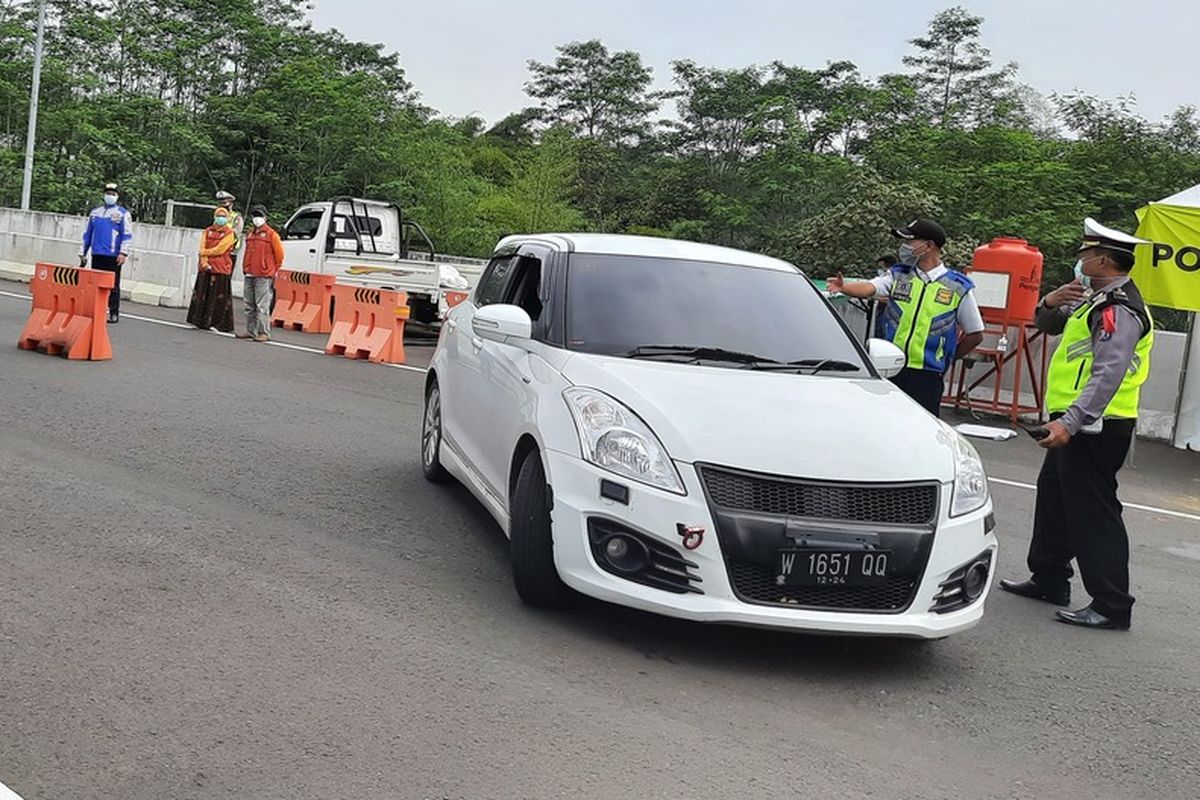 Police in the outskirts of the East Java city of Malang turn back a vehicle of people intent on traveling for the holidays on Friday (7/5/2021).