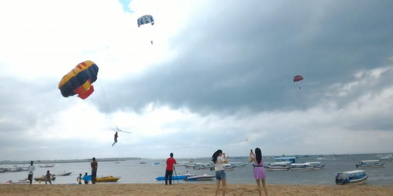 Wisatawan saat bermain parasailing di Pantai Tanjung Benoa