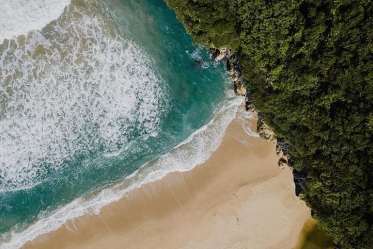 Pemandangan dari atas pantai berpasir putih dengan air laut biru jernih di Aceh, menawarkan keindahan alam tropis yang masih alami dan menenangkan. 