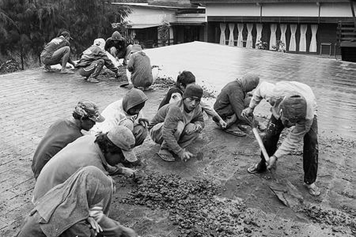 Pekerja membersihkan debu di atap penginapan Java Banana yang berlokasi di dekat Taman Nasional Bromo Tengger Semeru, Jawa Timur, Senin (20/12). Gunung Bromo kembali meletus hari Senin sekitar pukul 02.00, memuntahkan debu vulkanik yang menghujani desa dan tempat tujuan wisata di kawasan itu.