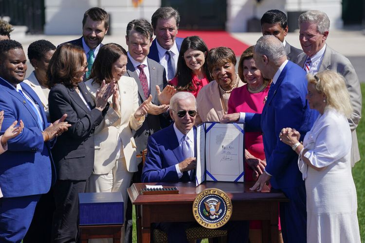 Presiden Joe Biden memegang CHIPS and Science Act of 2022 setelah menandatanganinya saat upacara di South Lawn Gedung Putih, Selasa, 9 Agustus 2022, di Washington. 
