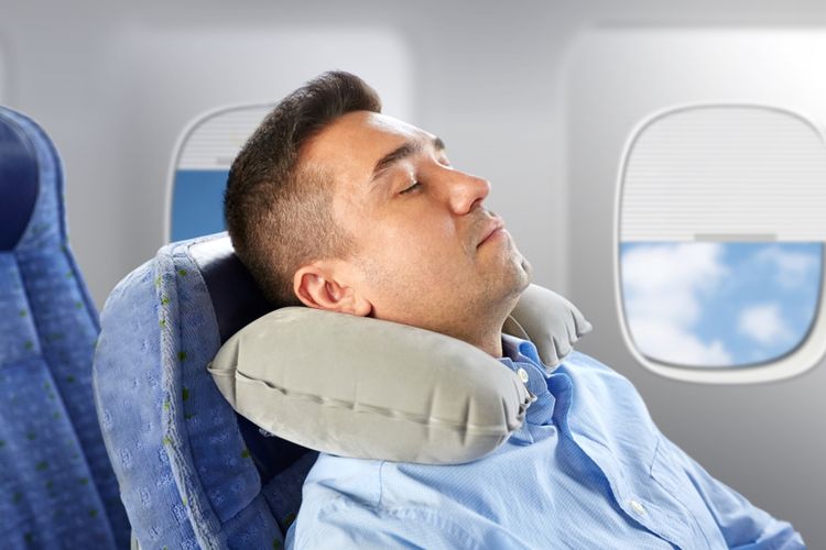 Ilustrasi tidur menggunakan bantal leher tiup di pesawat.