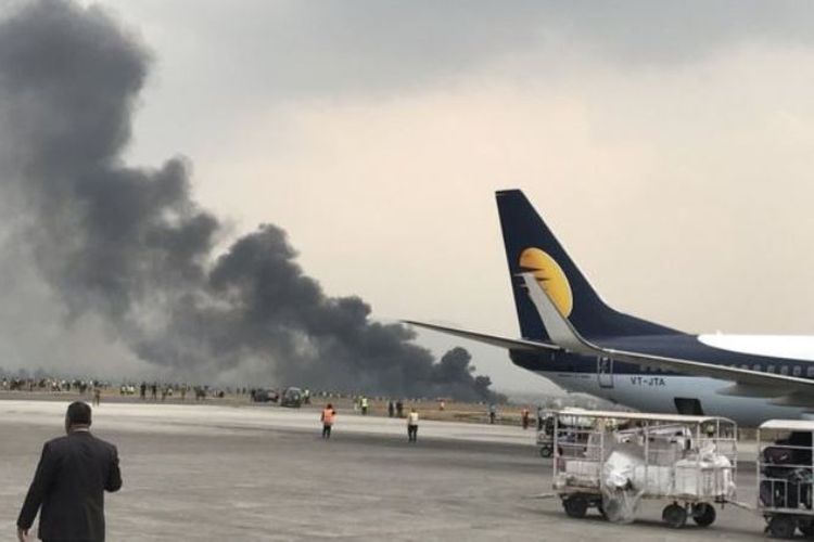 Asap hitam membubung dari lokasi tergelincirnya pesawat milik maskapai penerbangan US-Bangla di bandara internasional Tribuvhan, Kathmandu, Nepal, Senin (12/3/2018).