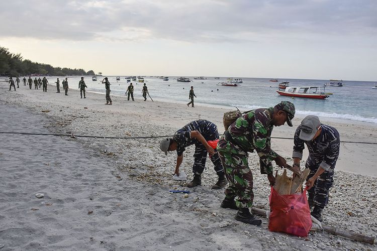 Aparat TNI  membersihkan sampah di pantai wisata Gili Trawangan, Desa Gili Indah, Pemenang, Tanjung, Lombok Utara, NTB, Rabu (8/8/2018).Sejumlah aparat TNI dan Polri disiagakan di kawasan wisata Tiga Gili untuk keamanan kawasan wisata yang ditinggal mengungsi oleh warga dan wisatawan pascagempa Lombok.