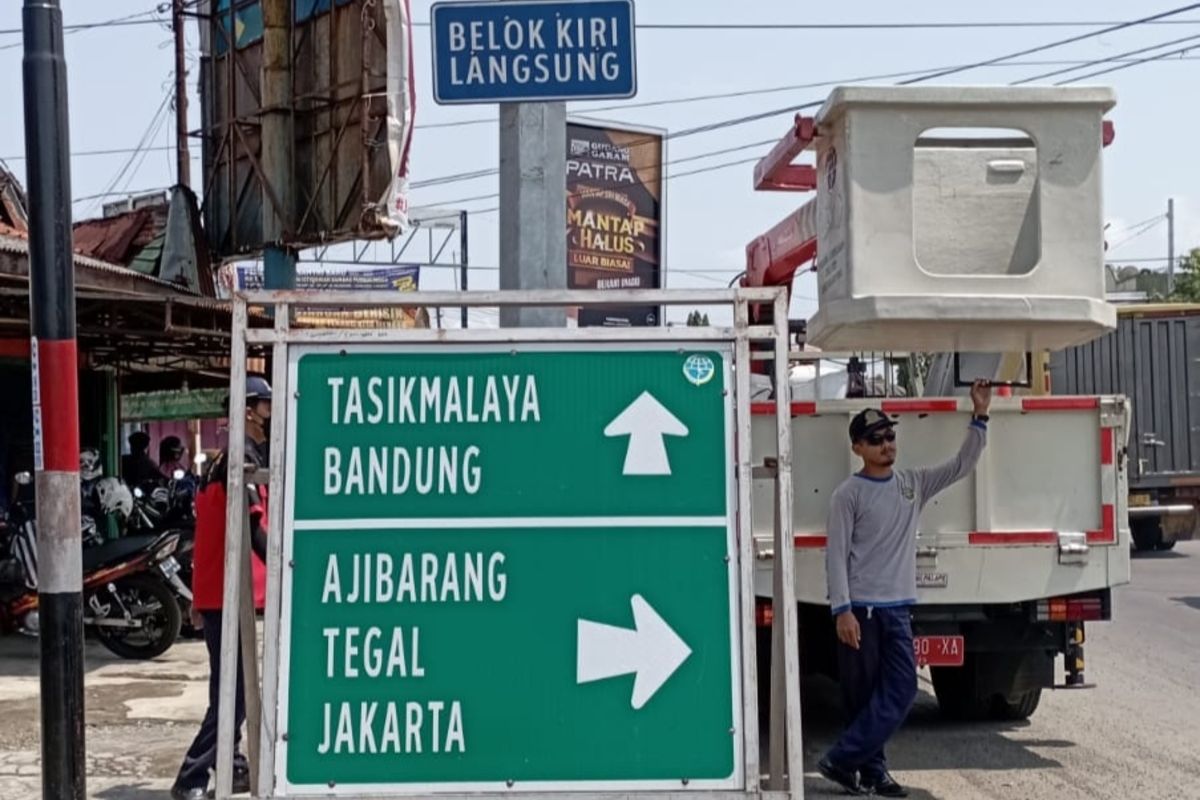 Petugas Dinas Perhubungan (Dinhub) Banyumas, Jawa Tengah, memasang rambu penunjuk jalan, baru-baru ini.