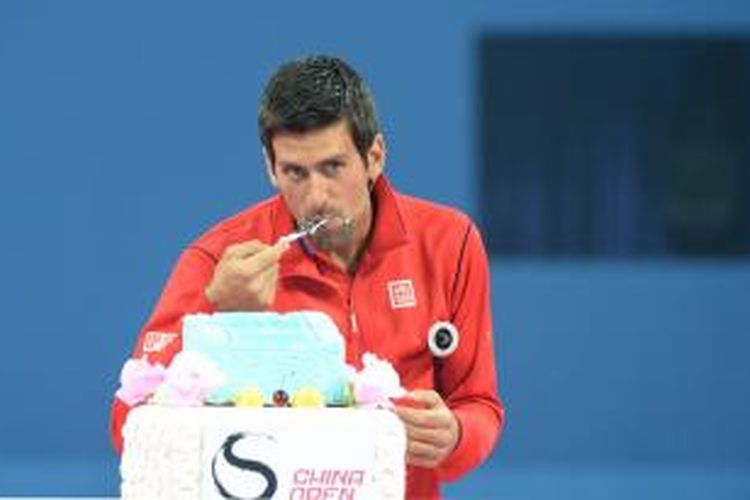 Petenis Serbia, Novak Djokovic, mencicipi kue sebelum menjalani pertandingan amal melawan Li Na dari China, sebelum turnamen China Open yang berlangsung di Beijing, Jumat (27/9/2013).