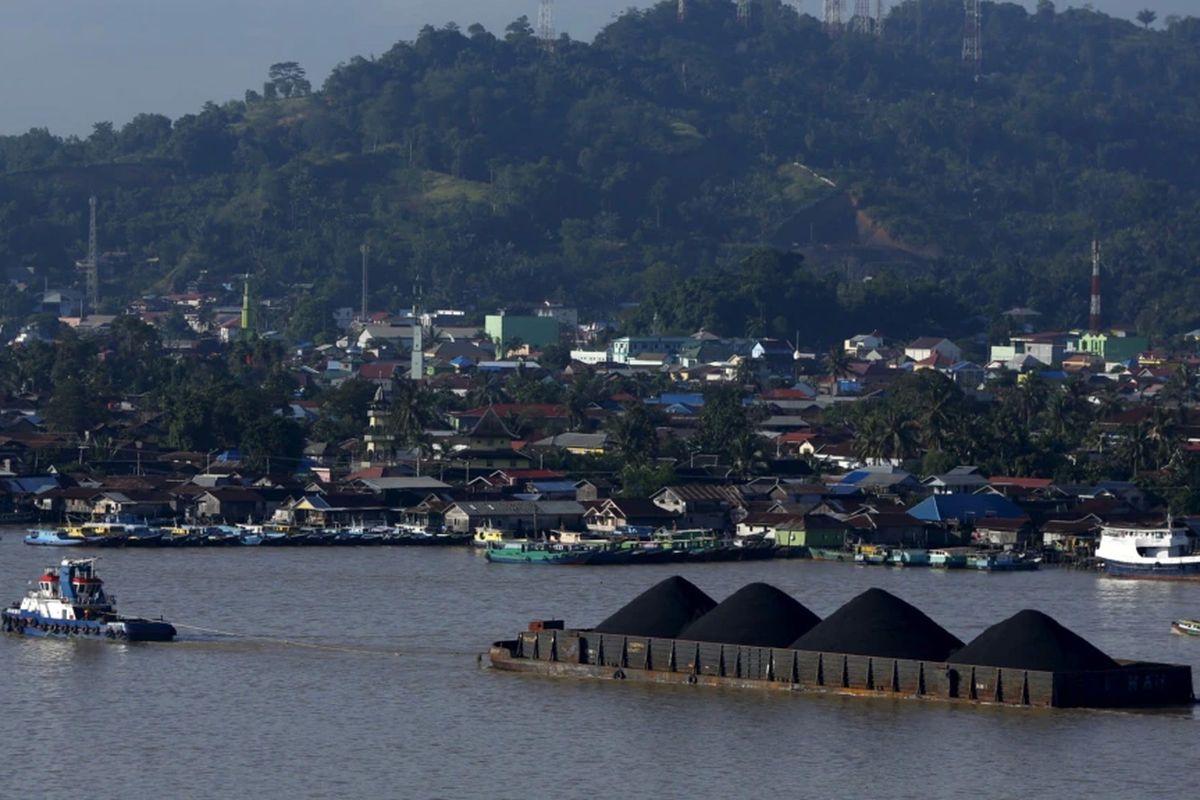 Sebuah kapal menarik tongkang batubara di sepanjang Sungai Mahakam, Samarinda, Kalimantan Timur.