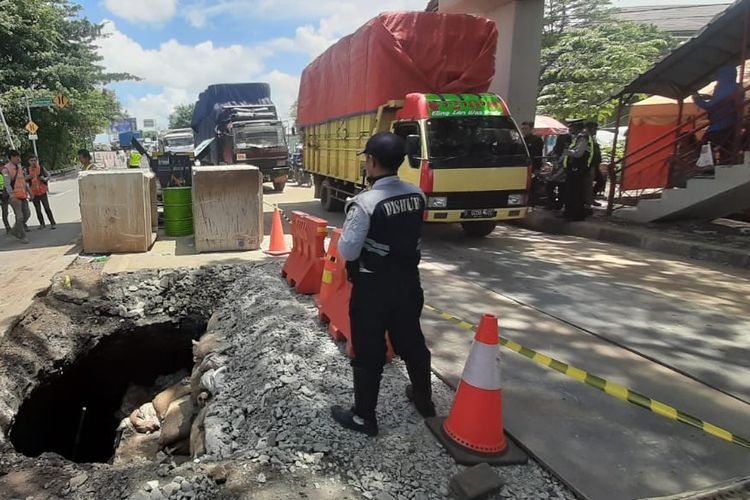Jalan ambles di Kilometer 22 Jalan Daan Mogot Kota Tangerang setelah diurug di hari kedua pascaambles, Selasa (14/1/2020)