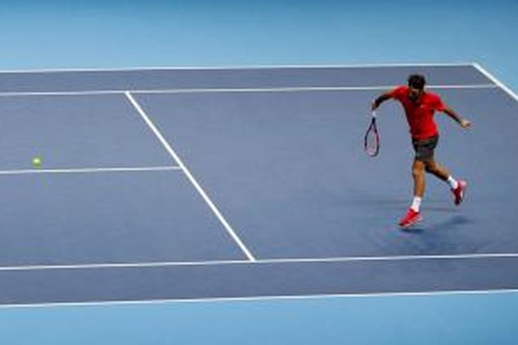 Petenis Swiss, Roger Federer, mengambalikan bola dari petenis Jepang, Kei Nishikori, pada pertandingan lanjutan Grup B ATP Wolrd Tour Finals di London, Selasa (11/11/2014).