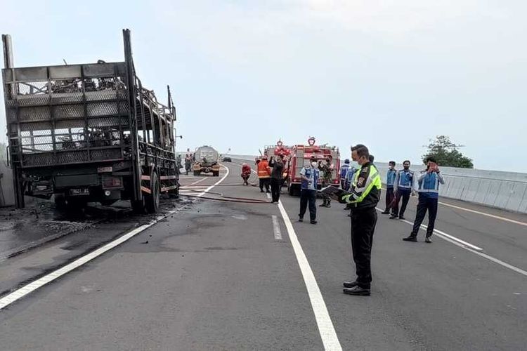 Aparat kepolisian dan petugas Damkar berhasil memadamkan api yang melahap truk bermuatan puluhan motor di Jalan Tol Trans Jawa KM 669+200 A, Desa Pecuk, Kecamatan Patianrowo, Nganjuk, Selasa (2/11/2021). Foto: Satlantas Polres Nganjuk