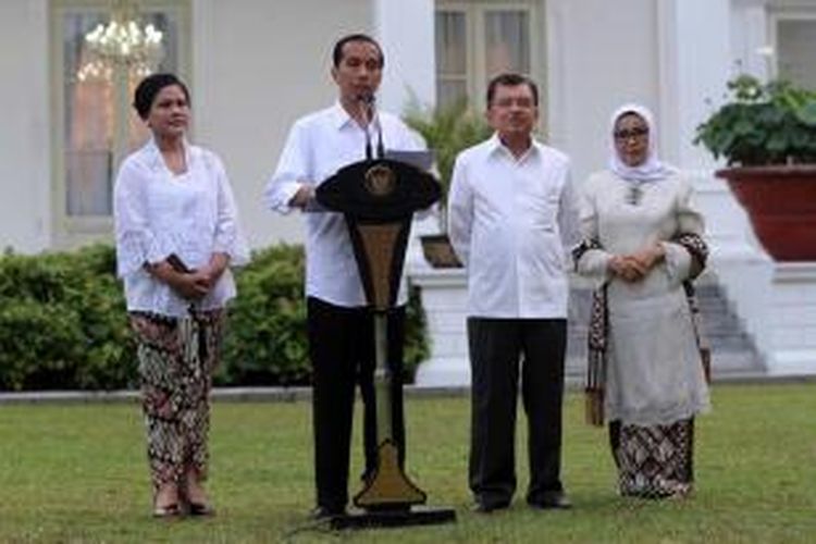 Presiden Joko Widodo dan Wakil Presiden Jusuf Kalla bersama Ibu Negara Iriani Joko Widodo serta Ibu Mufidah Jusuf Kalla mengumumkan nama-nama menteri di halaman Istana Merdeka, Jakarta, Senin (26/10/2014).