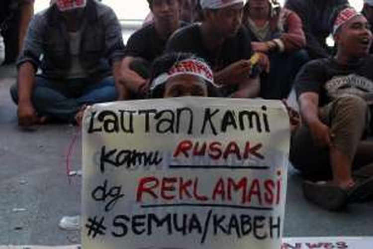 Massa Gempur membentangkan poster menolak reklamasi, dalam demo di depan Kantor Bupati Gresik, Senin (25/4/2016). 