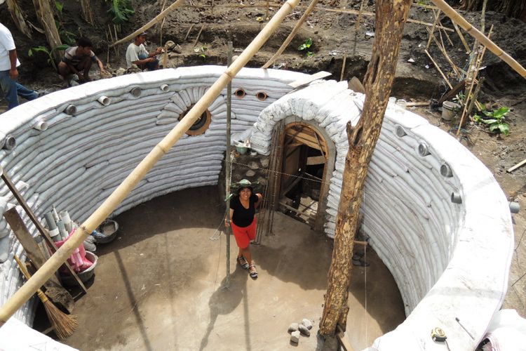 Iswanti saat berfoto di tengah-tengah lingkaran dinding rumahnya yang terbuat dari karung beras berisi material alami. Rumah saat difoto dalam tahap pembangunan. Rumah dengan konsep tahan gempa dan ramah lingkungan ini terletak di Jalan Raya Prambanan, tepatnya di Dusun Tamanan Pabrik, Desa Tamanmartani, Kecamatan Kalasan, Kabupaten Sleman, Yogyakarta.