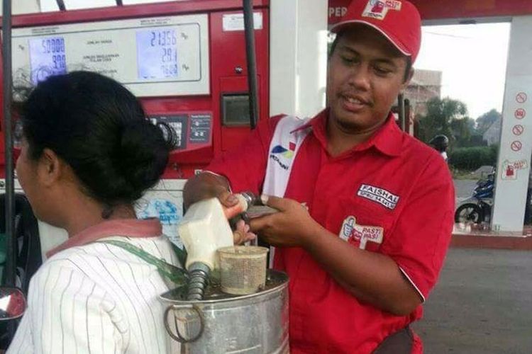 Emak-emak sedang mengisi bahan bakar minyak (BBM) dengan wadah bekas jeriken penyemprot padi.