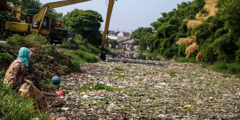 Seorang pemulung mengambil sampah yang didominasi plastik di sepanjang Kali Pisang Batu, Desa Pahlawan Setia, Kecamatan Tarumajaya, Kabupaten Bekasi, Jawa Barat, Selasa (8/1/2019). Sampah yang memenuhi Kali Pisang Batu hingga sepanjang 1,5 kilometer berasal dari Kali Bekasi yang melewati Kota Bekasi. Sampah muncul pasca normalisasi dilakukan pada Desember 2018. Sebelumnya, kali hanya dipenuhi lumpur dan eceng gondok.