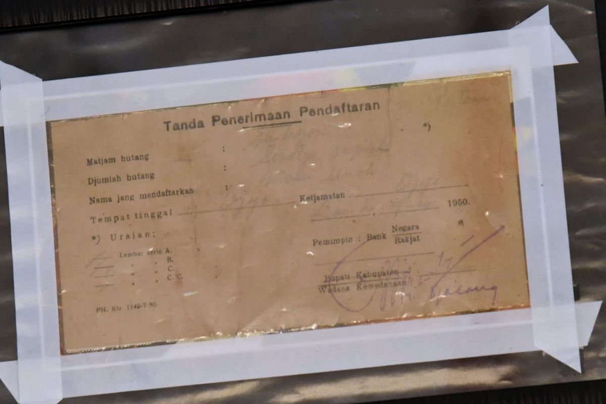 Surat obligasi tahun 1950 milik Nyak Sandang yang diperlihatkan kepada Presiden Joko Widodo di Istana Merdeka Jakarta, Rabu (21/3/2018).