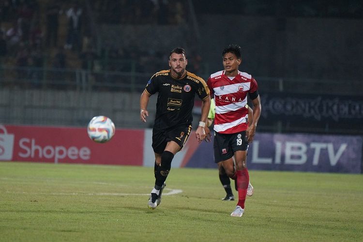 Marko Simic dan Fachruddin Aryanto berlari mengejar bola dalam pertandingan Madura United vs Persija Jakarta pada lanjutan Liga 1 2023-2024 di Stadion Gelora Bangkalan, Minggu (13/8/2023) malam WIB. 
