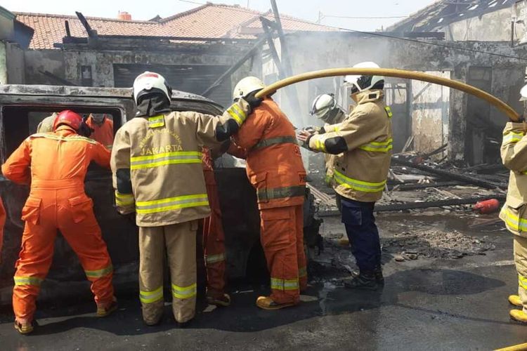 Petugas pemadam kebakaran memadamkan sebuah mobil Daihatsu Luxio bernomor polisi B 1894 TOB ludes terbakar di Kampung Sumur Bor, Jalan Raya Penggilingan, RW 01, Cakung, Jakarta Timur, Senin (29/6/2020).