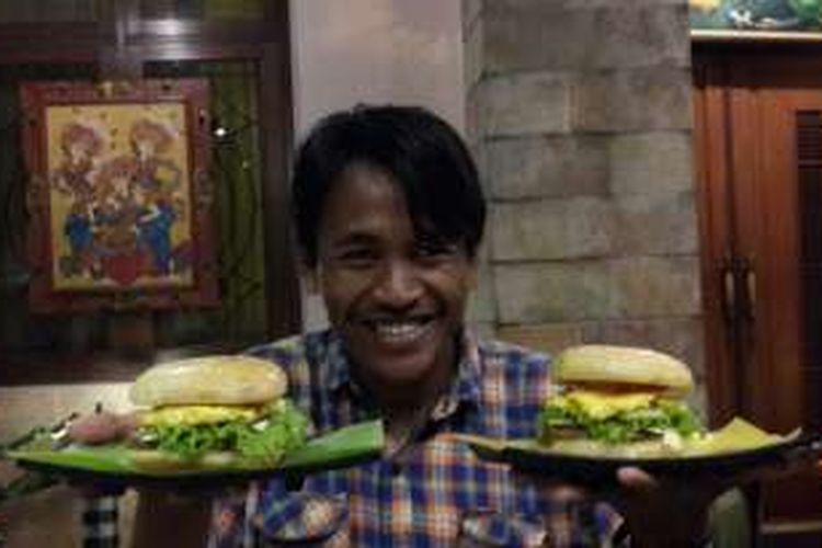 Seorang pembeli saat menunjukkan Burger Om Telolet yang terbungkus daun pisang di Kota Malang, Jawa Timur, Selasa (20/12/2016).