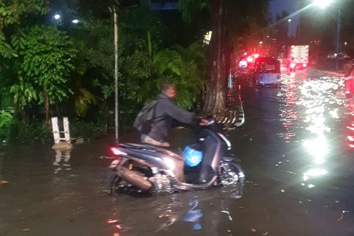 Pengendara sepeda motor mendorong kendaraannya akibat menerobos banjir di Jalan Cempaka Putih Barat 26, Cempaka Putih, Jakarta Pusat, Kamis (6/10/2022).