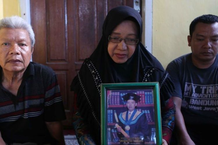 Hasna Dani Paita (tengah) mendekap bingkai foto anak pertamanya, Wahyudin S Lamampara, yang meninggal dunia dalam ledakan tungku smelter nikel di PT ITSS Morowali pada Minggu (24/12/2023)