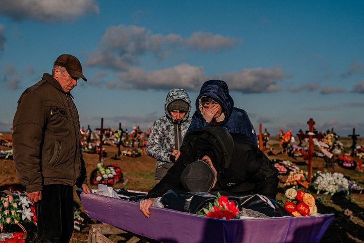 Kerabat berduka atas peti mati Ukranian Olena Afanasievska, yang terbunuh dalam serangan rudal Rusia pada 24 Desember, saat upacara pemakaman di selatan kota Kherson pada 28 Desember 2022.