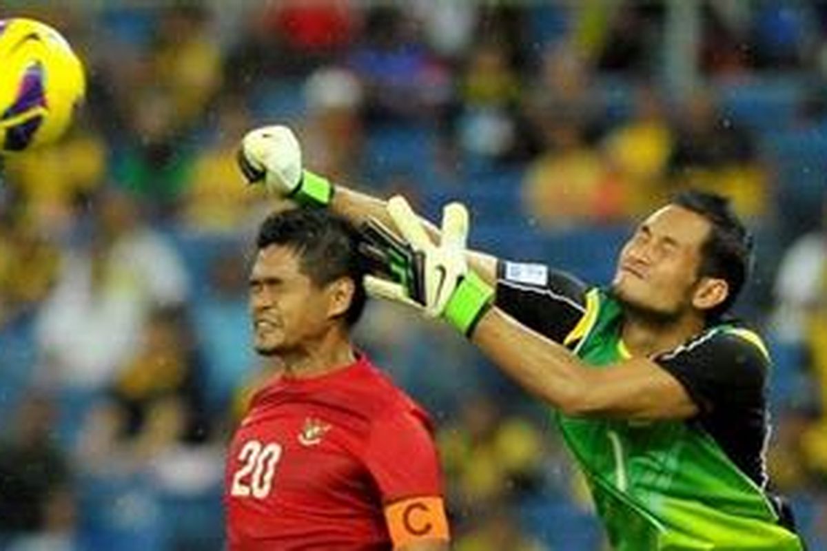 Penjaga gawang tim Laos Sengphachan Bounthisanh menghalau bola yang disundul oleh pemain Timnas Indonesia Bambang Pamungkas dalam laga Piala AFF 2012 di Stadion Nasional Bukit Jalil, Kuala Lumpur, Malaysia, Minggu (25/11/2012). Pertandingan berakhir imbang dengan skor 2-2.