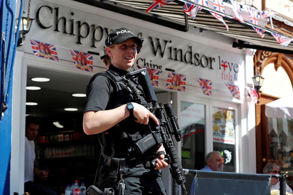 Seorang anggota polisi Inggris memegang senjatanya saat berjaga di Windsor Castle di Windsor, timur London 15 Mei 2018. AFP PHOTO / Adrian DENNIS