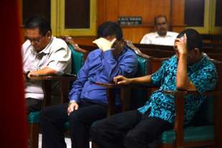 Terus menunduk dan menutupi wajahnya supaya terhindar dari bidikan kamera. Ketiganya adalah terdakwa korupsi alat kesehatan (alkes) di RSUD Pirngadi Medan. 