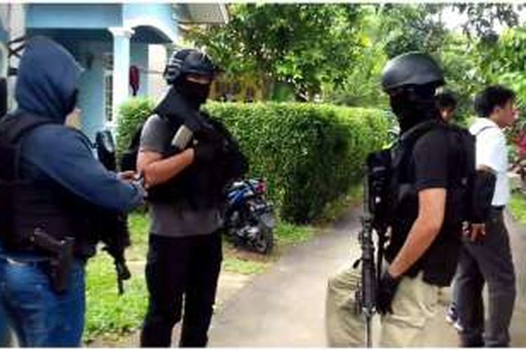Anggota Densus 88 sedang mendekati sebuah rumah yang dihuni terduga teroris di Setu, Tangerang Selatan, Rabu (21/12/2016).