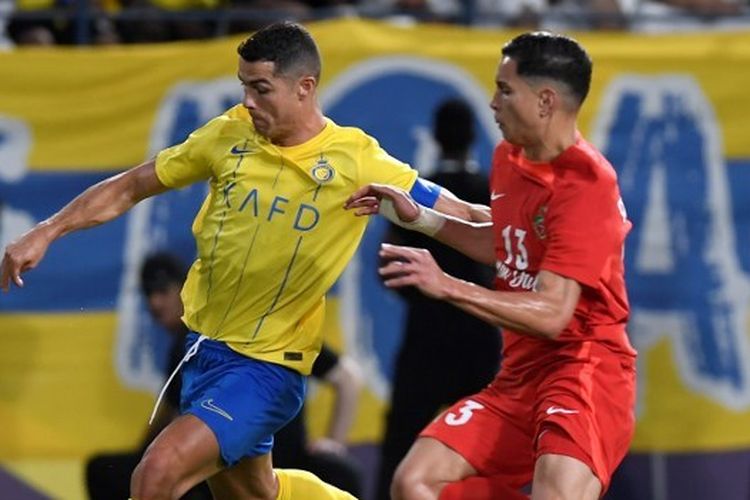 Penyerang Portugal, Cristiano Ronaldo, ketika berebut bola dengan bek Shabab Al-Ahli, Renan, dalam playoff Liga Champions Asia yang mempertemukan Al Nassr vs Shabab Al Ahli di Stadion King Saud University pada 22 Agustus 2023. (Foto oleh AFP)