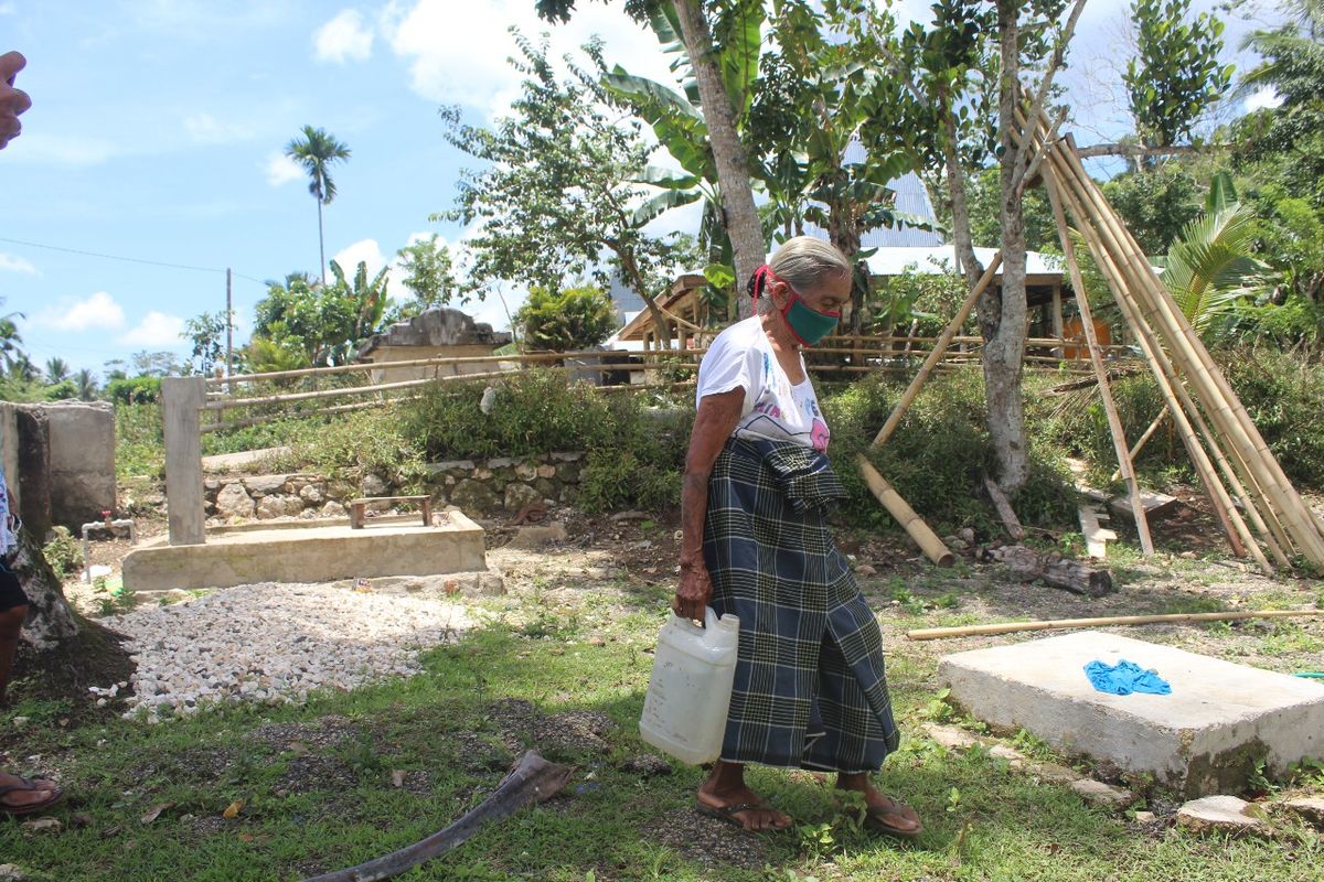 Seorang warga sedang menenteng jeriken air bersih yang ditimba pada keran air di dekat rumahnya di Desa Tana Rara, Kecamatan Loli, Kabupaten Sumba Barat, Nusa Tenggara Timur (NTT).