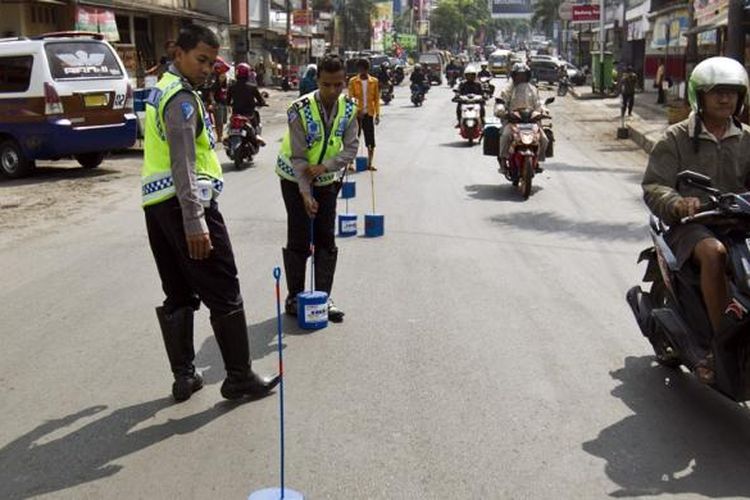 Petugas dari Kepolisian Resor Sumedang memasang marka jalan di seputar Jalan Mayor Abdurahman, Sumedang, Jawa Barat, Senin (29/7/2013). Pemasangan ini untuk memberikan tanda batas jalan karena daerah ini merupakan kawasan padat saat arus mudik berlangsung. 