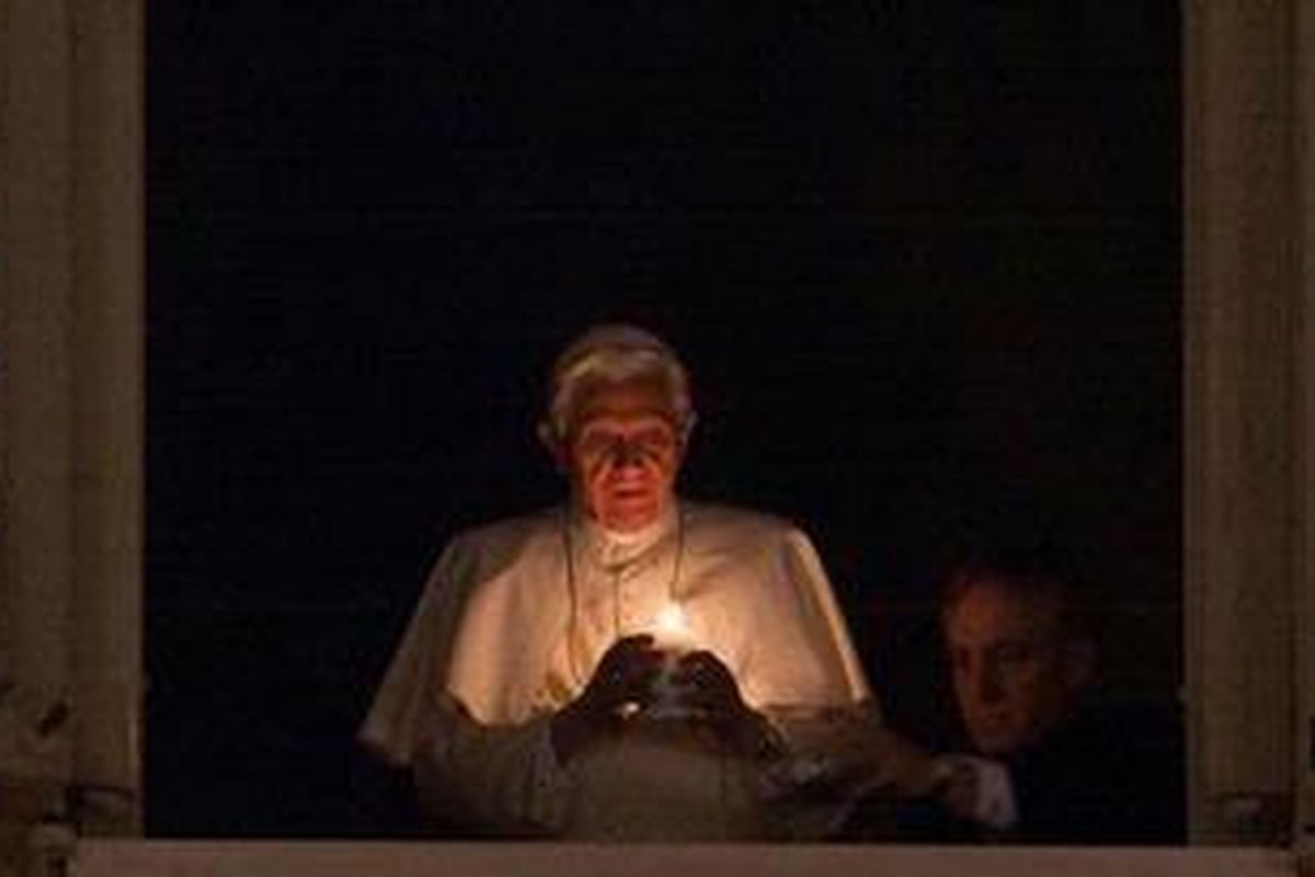 Paus Benediktus XVI menyalakan lilin di jendela pribadinya, Sabtu (24/12/2011) petang.