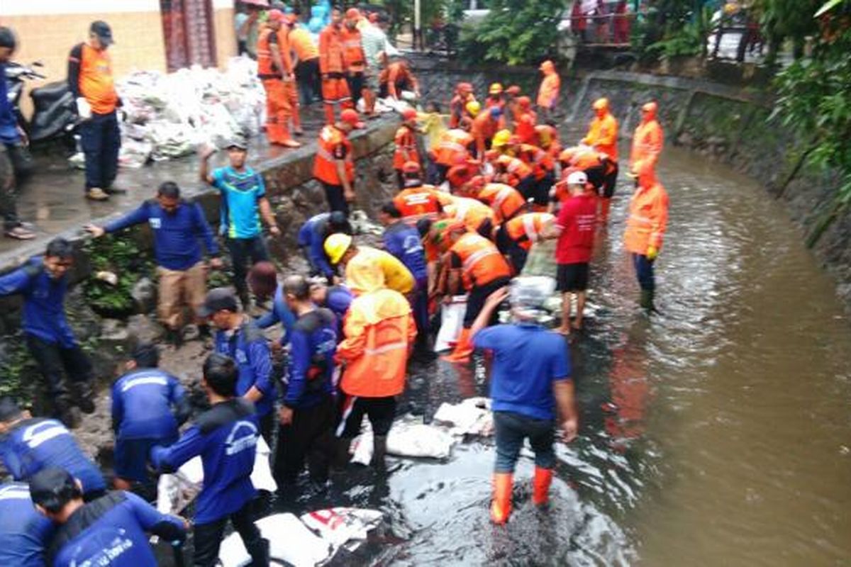 Petugas membersihkan saluran air penghubung (Phb) di Jalan PLK II, Kelurahan Makasar, Kecamatan Makasar, Jakarta Timur. Minggu (19/2/2017)