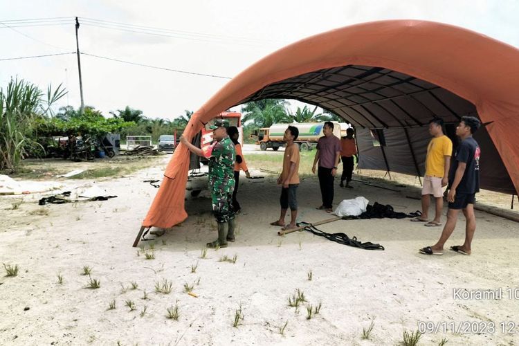 Petugas mendirikan tenda tempat belajar siswa SMA Negeri 2 Bonai Darussalam, Kabupaten Rokan Hulu, Riau, yang terdampak banjir, Kamis (9/11/2023).